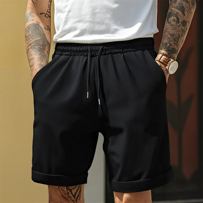 Man wearing stylish versatile men's cuffed shorts with elastic waist, ideal for summer fashion & everyday casual comfort.