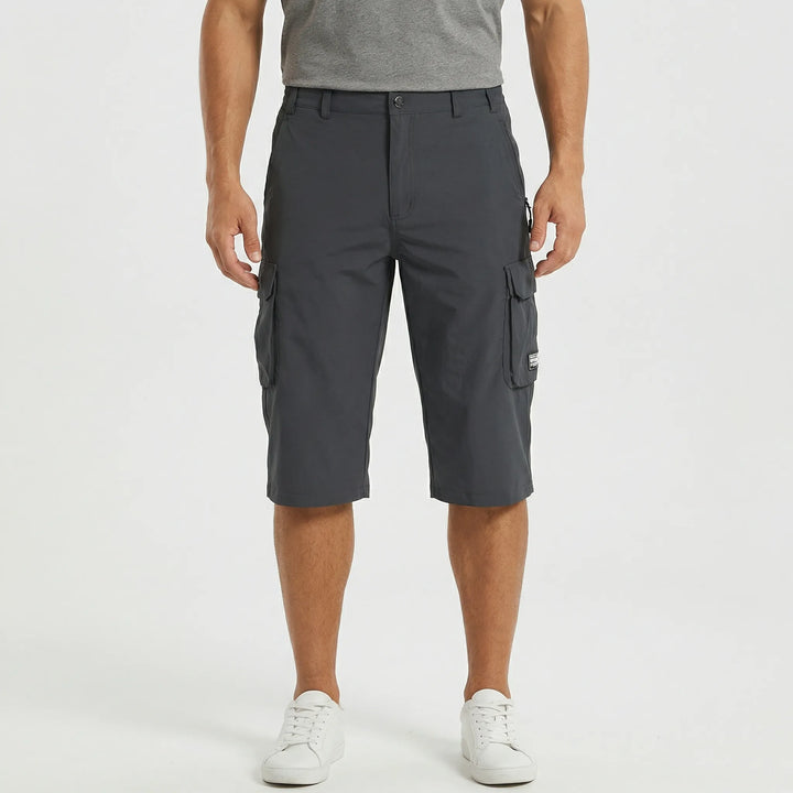 Detail of elastic waistband & quick-dry fabric on men's versatile cargo shorts. Comfort for active summer days.