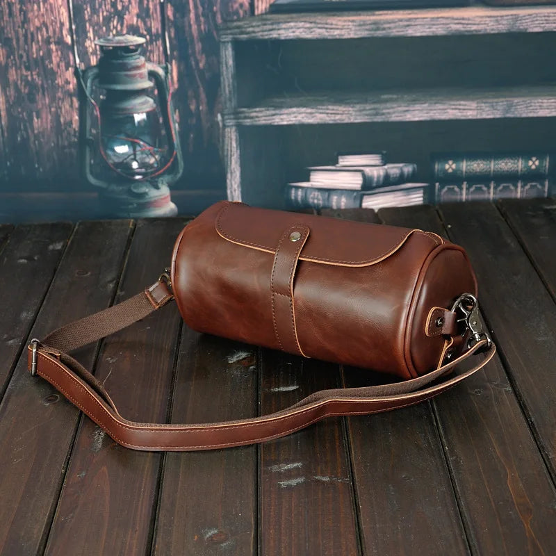 Stylish PU leather men's barrel bag. Vintage design, durable shoulder & cross-body accessory.