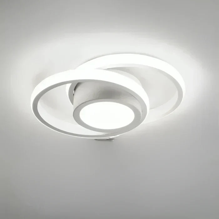 Artistic LED double ring lamp, Twilight Rings, enhances home decor with contemporary lighting.