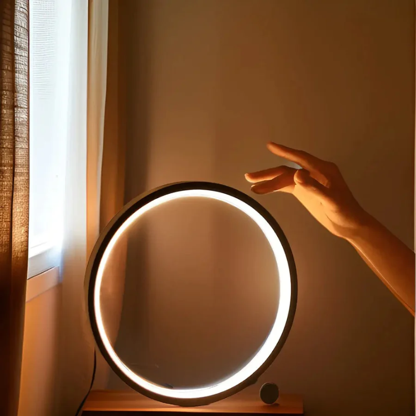 Modern LumaCircle dimmable LED table lamp, sleek round design, perfect for home office or bedroom ambient light.