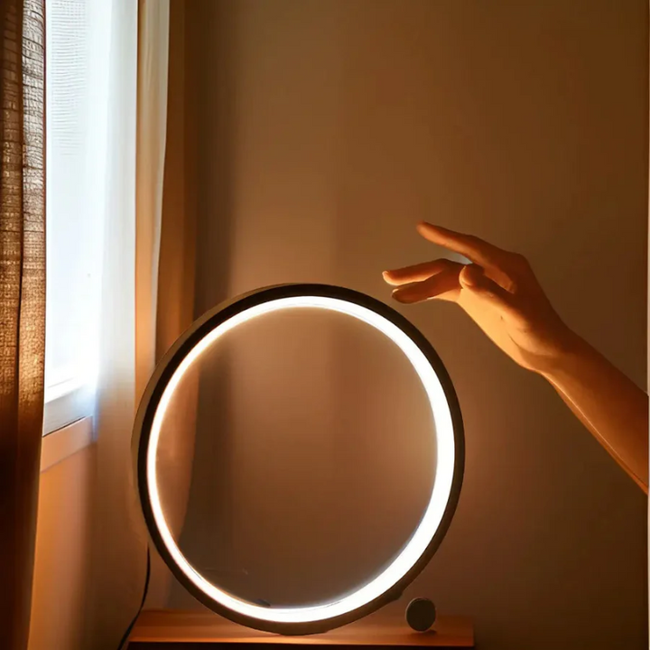 Modern LumaCircle dimmable LED table lamp, sleek round design, perfect for home office or bedroom ambient light.