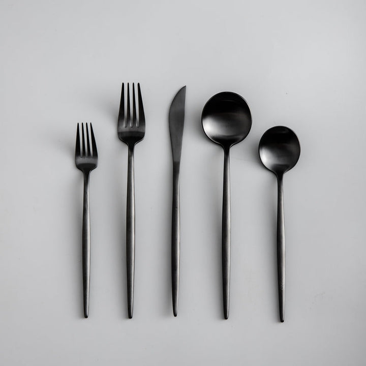 Close-up of a sleek matte black dinner knife from a modern cutlery set.