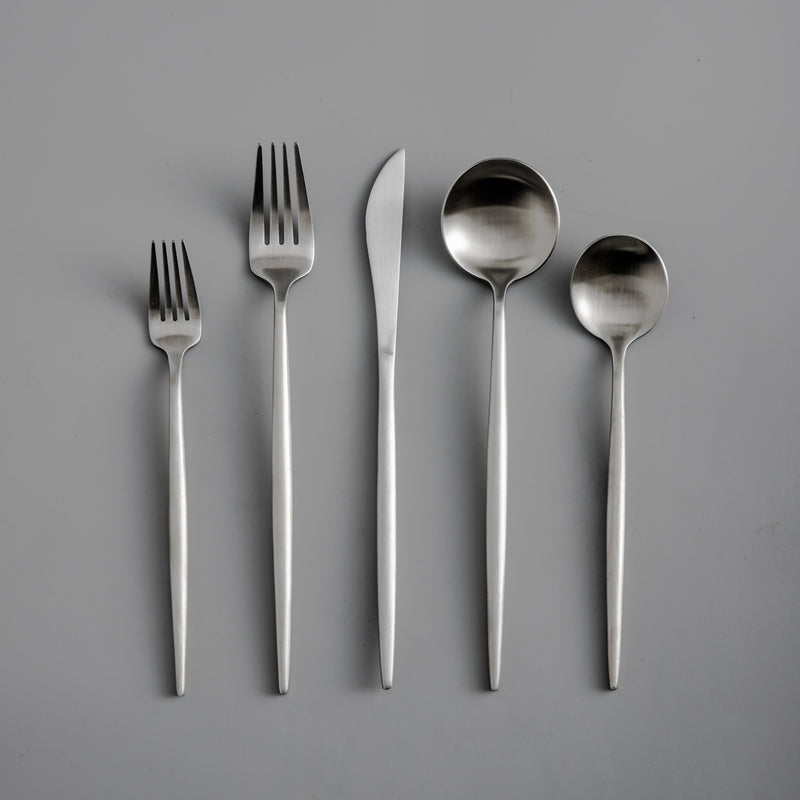 Modern dining experience with a matte gold flatware set, minimalist design.