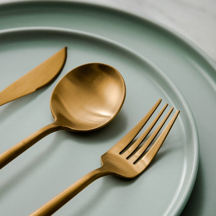 Close-up of a matte silver minimalist dinner fork, part of a modern dining set.