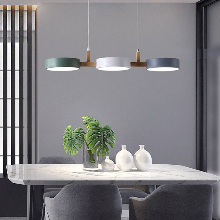 Elegant Scandinavian LED pendant lamp illuminating a dining room, wood & metal ceiling fixture.