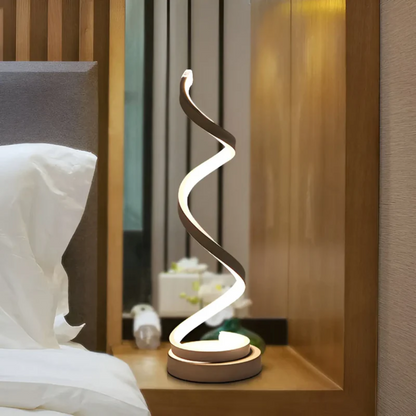 Dimmable modern spiral LED table lamp for stylish home or office ambient lighting.