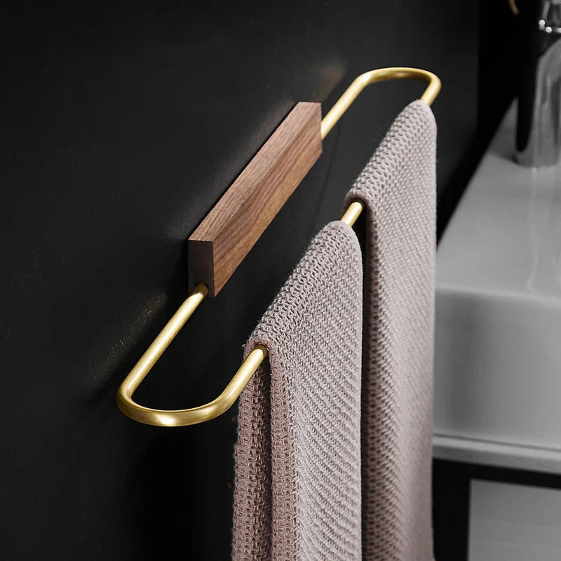 Modern walnut towel bar with brass accents, perfect for minimalist bathroom decor and home organization.