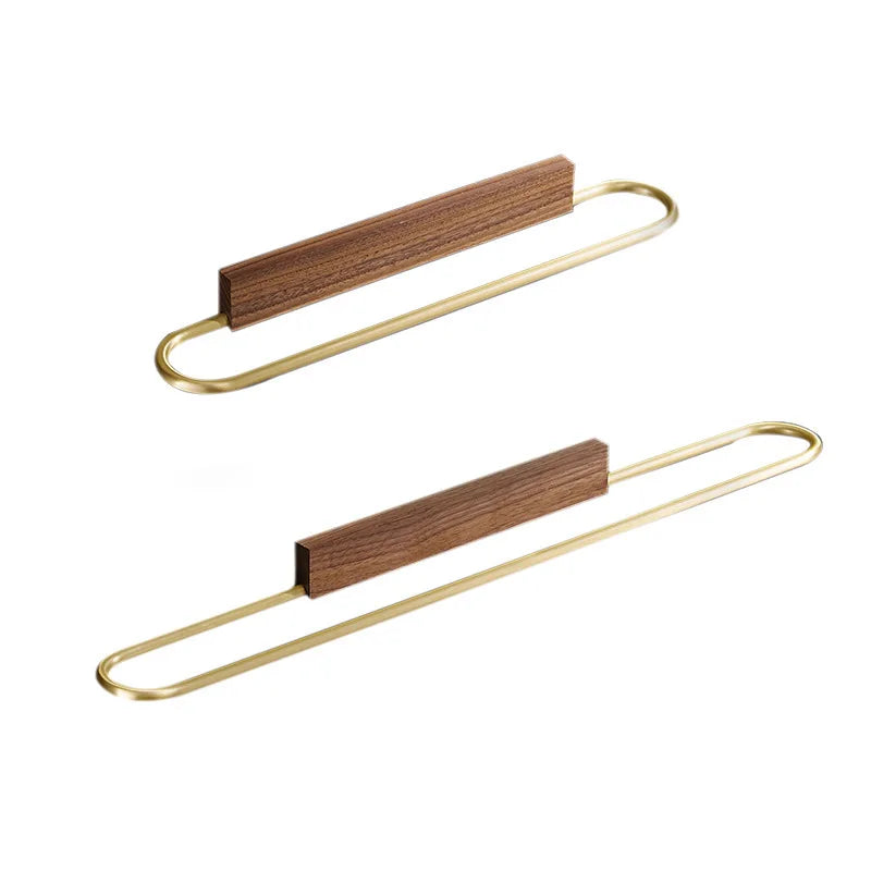 Minimalist modern walnut bathroom towel bar, wall-mounted for organization, featuring stylish brass details.