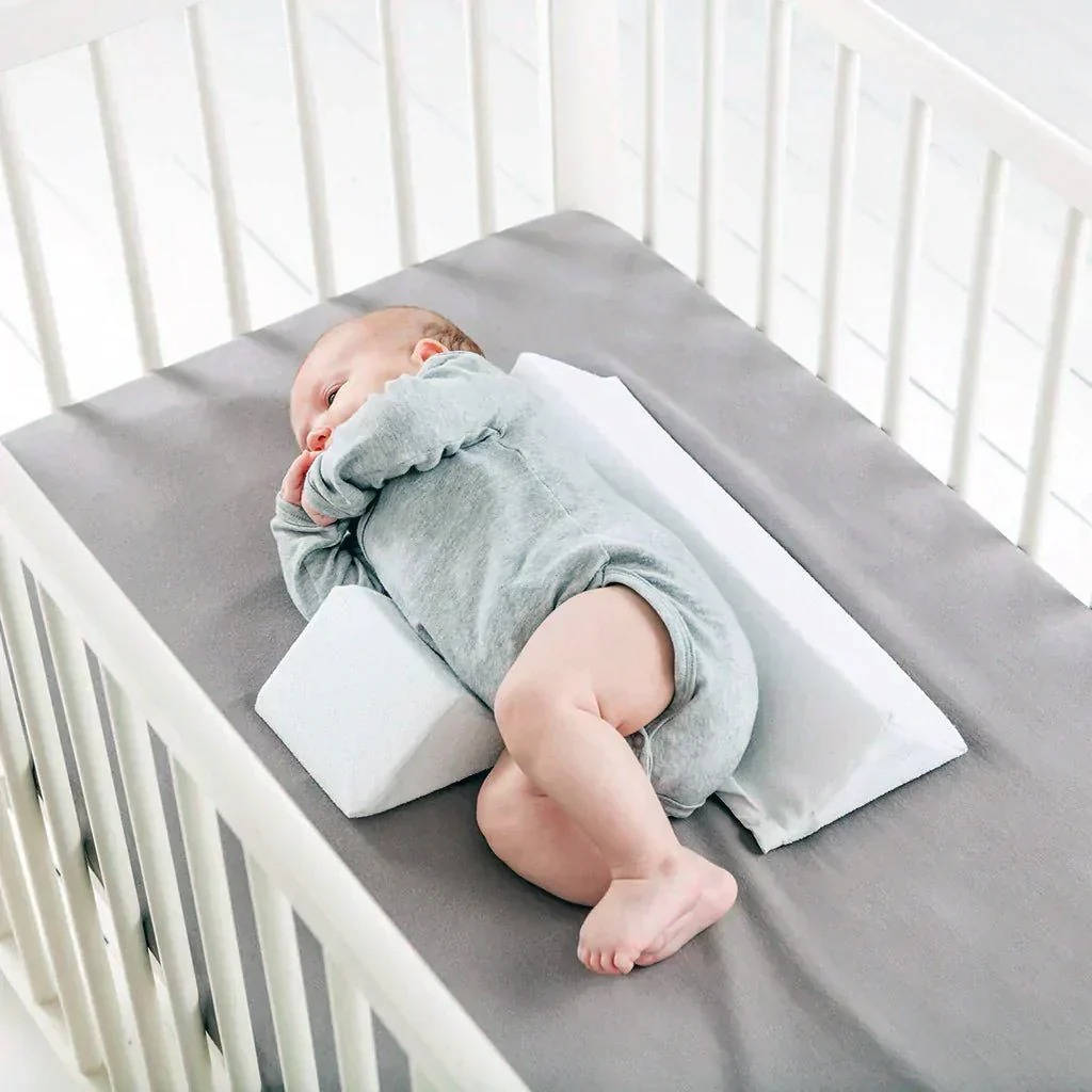 Anti-roll side sleeper wedge for infants, ensuring safe sleep and preventing discomfort for newborns.