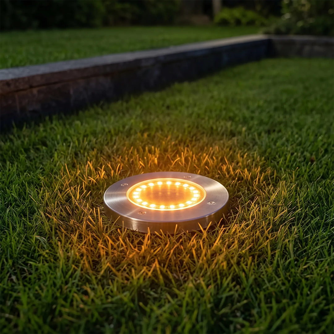 Outdoor solar disk lights illuminating a garden pathway, perfect for landscape lighting and lawn decor.