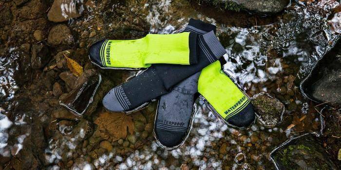 Model wearing black waterproof breathable hiking socks with outdoor boots.