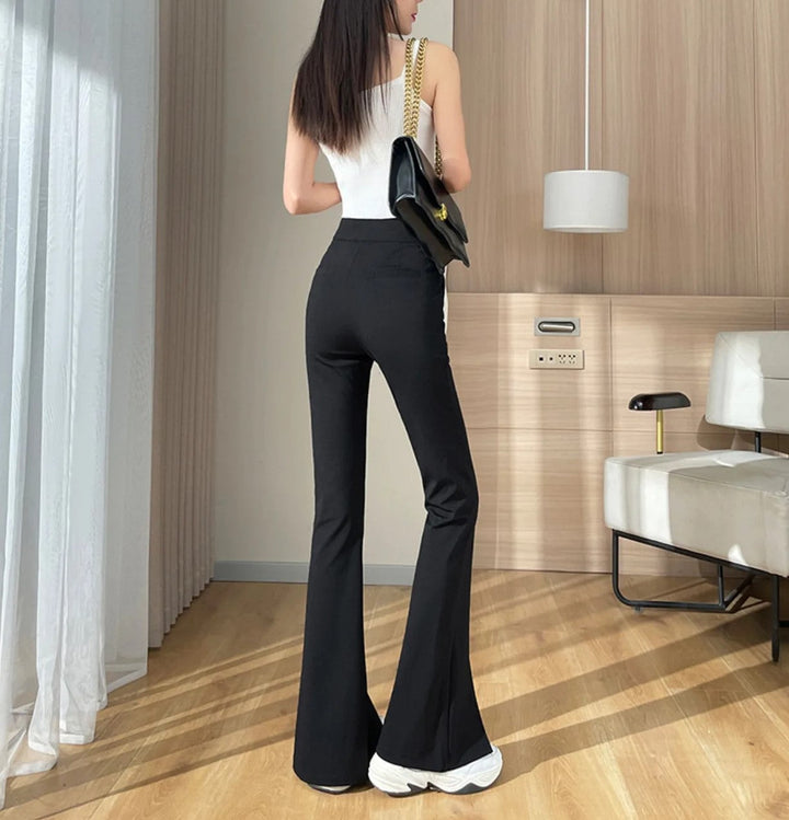 Plus size black high-waisted flared pants with sophisticated front leg slits. Women's elegant fashion.