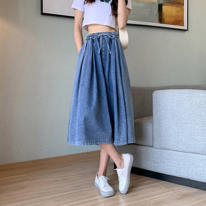 Plus-size model wearing stylish high-waist wide-leg denim skirt-pants, perfect for all-year fashion.