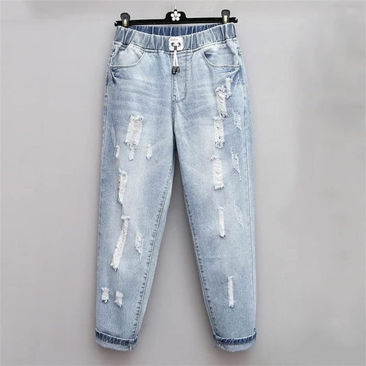 Plus-size women's ripped high-waisted oversized jeans in distressed blue denim, perfect for trendy casual wear.