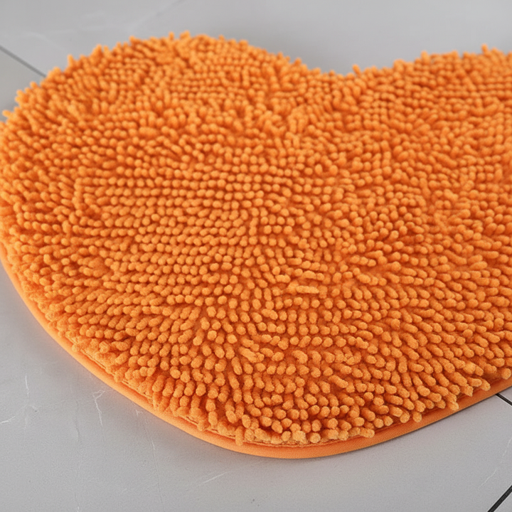 Yellow heart-shaped bath mat. Absorbent microfiber, non-slip, plush for cozy home bathroom decor.