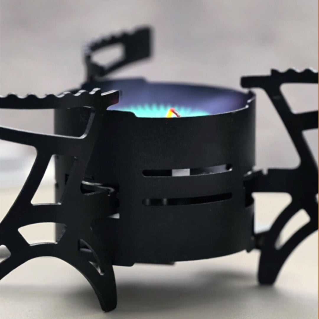 Outdoor cooking scene with a 3600W camping gas stove, boiling water on a scenic mountain backdrop.