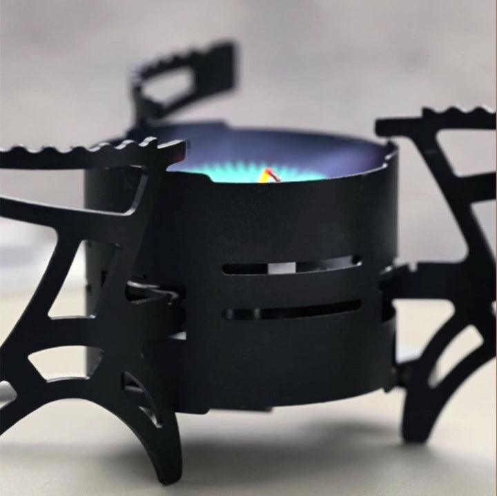 Outdoor cooking scene with a 3600W camping gas stove, boiling water on a scenic mountain backdrop.