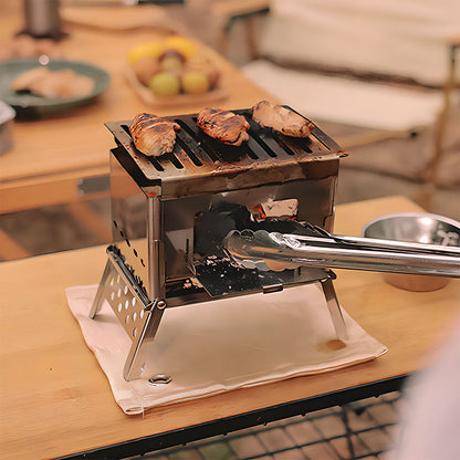 Portable camping wood stove and grill set up in a campsite, ready for an outdoor cooking experience.