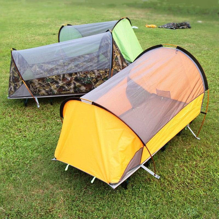 Outdoor gear: Portable off-ground camping tent (yellow/green) set up in nature, ready for adventure.