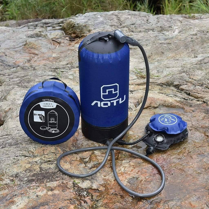 Man using portable foot pump pressure shower at a campsite, demonstrating outdoor cleaning & hygiene