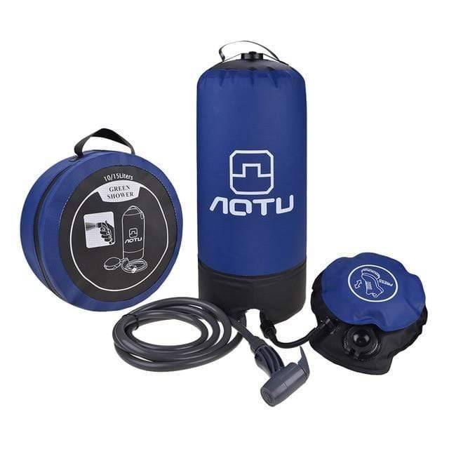 Portable camping pressure shower with foot pump on a rocky terrain, ready for outdoor adventures