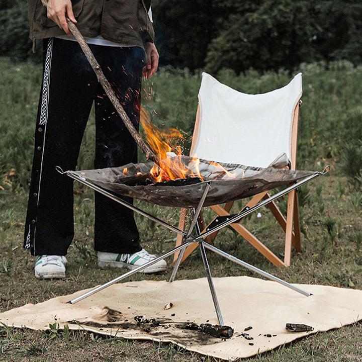 Compact stainless steel fire pit for camping, includes a removable grill rack for easy outdoor meals.