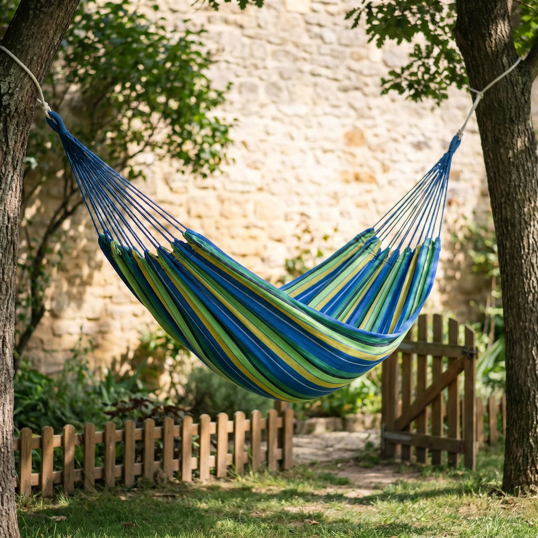Portable striped canvas hammock for outdoor camping & backyard relaxation. Lightweight travel garden furniture.