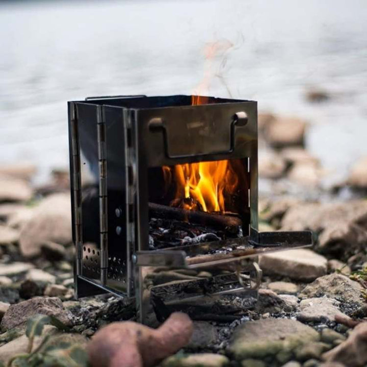 Side view of portable wood burning stove with flame visible, ideal for camping & hiking