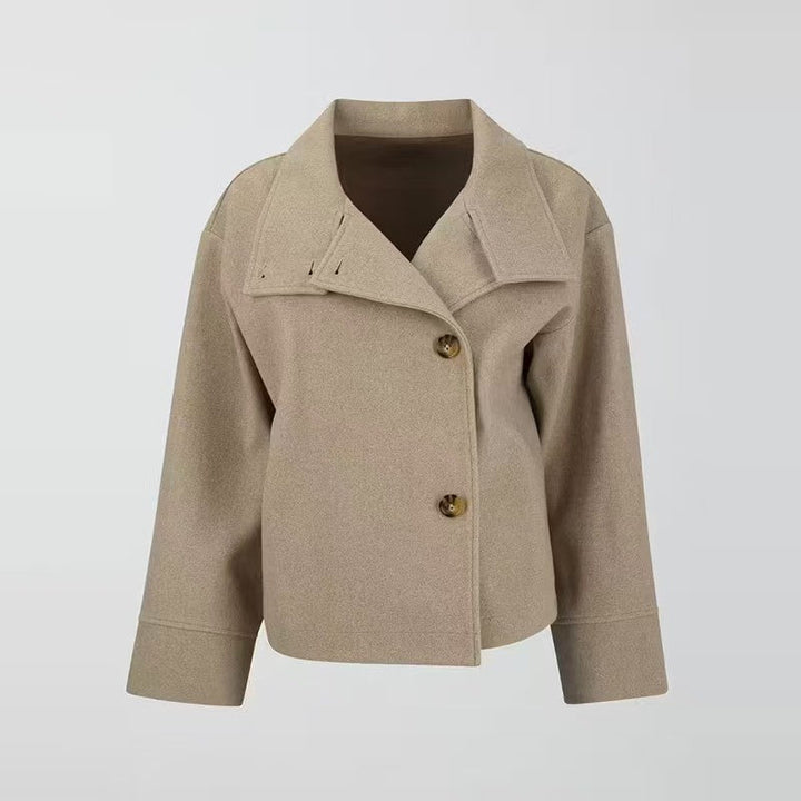 Modern women's short coat with button closure, high neck, and relaxed fit. A chic layering piece for fall fashion.