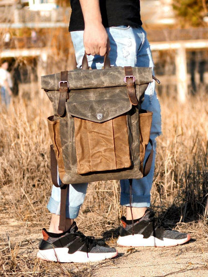 Tan canvas and dark leather vintage backpack, ideal for travel.