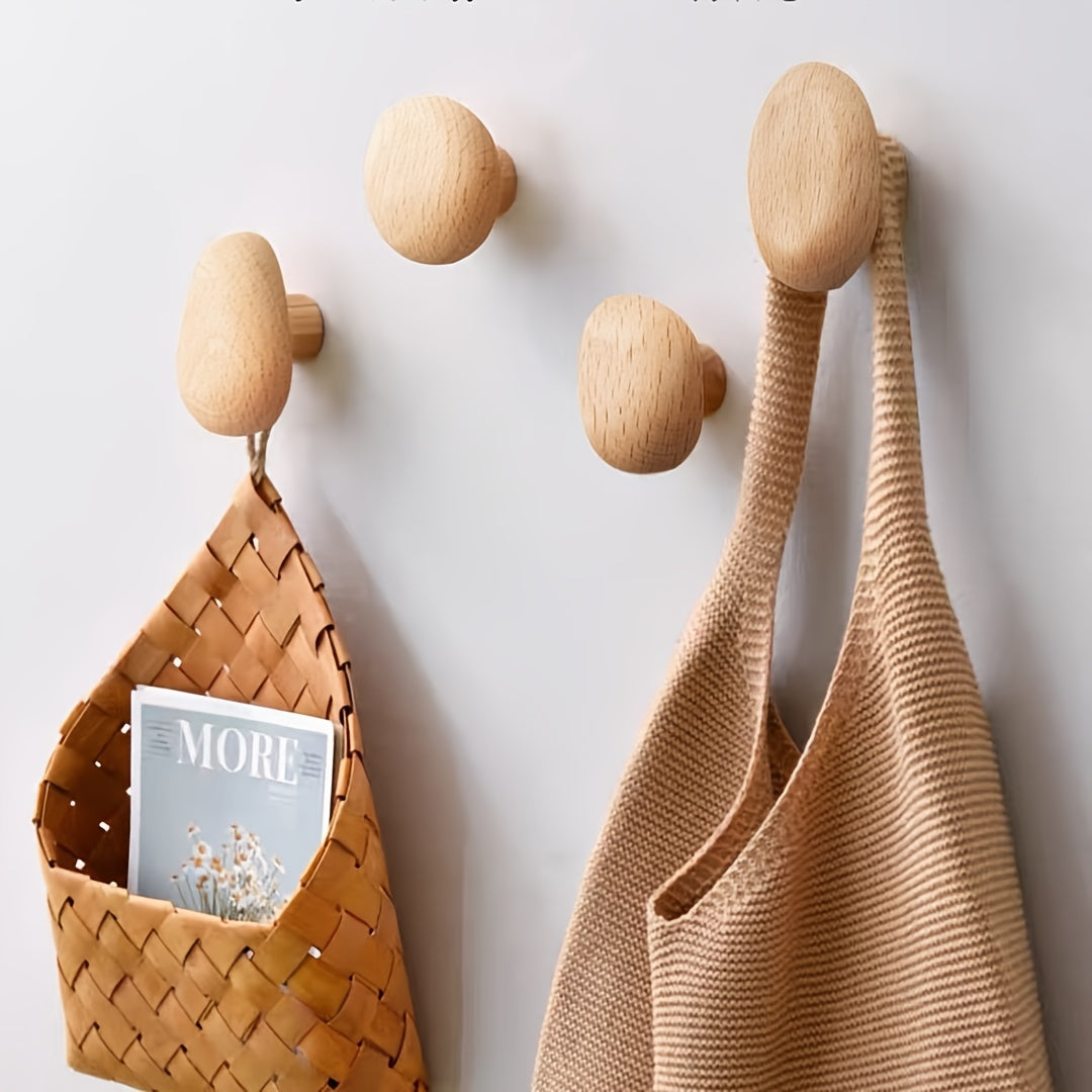 Smooth pebble-shaped natural wooden wall hooks. Set of 4 solid wood hooks for stylish home organization.
