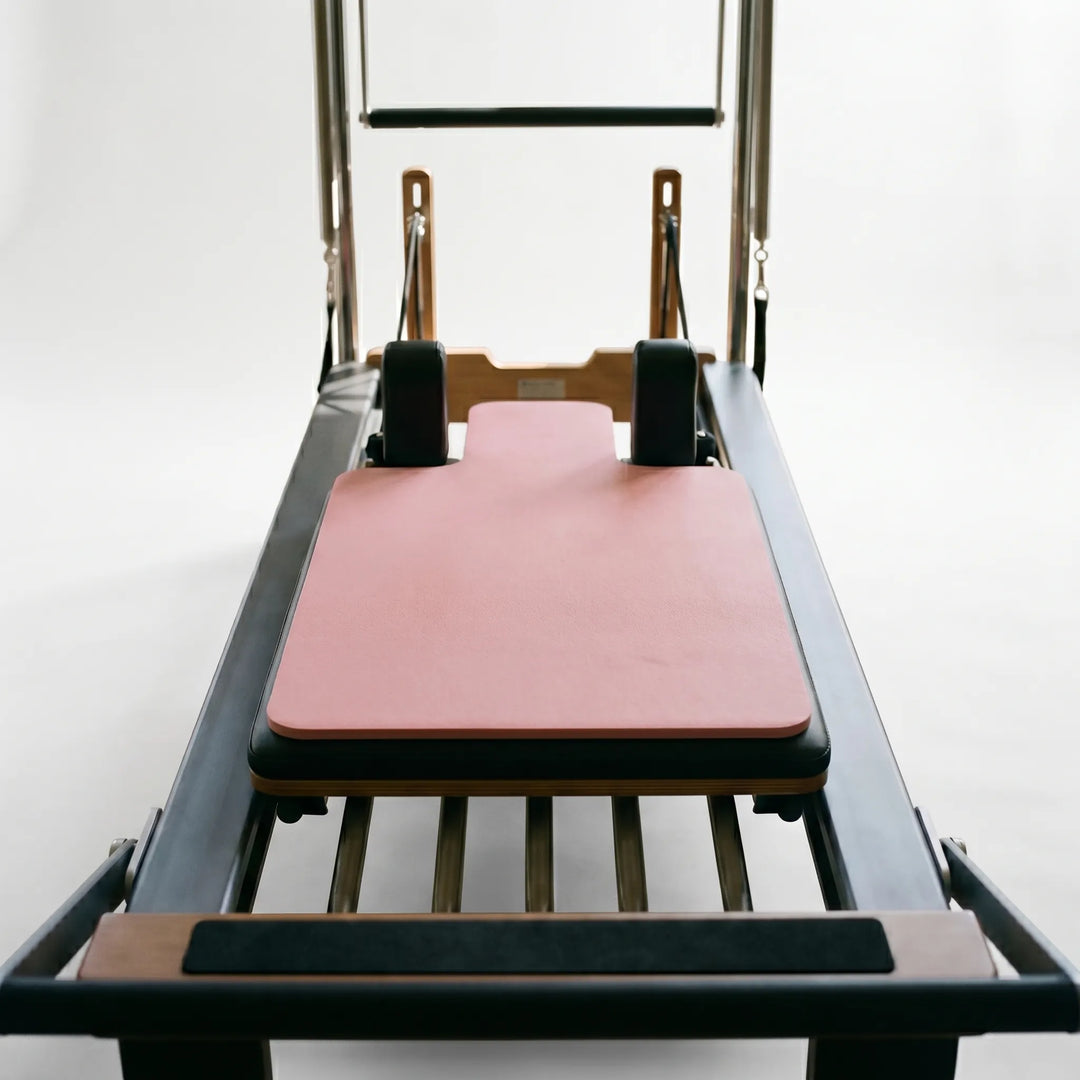Non-slip, shaped Pilates reformer pad for enhanced comfort & stability during studio workouts. Portable fitness.