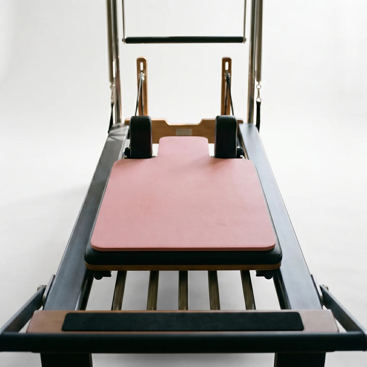 Non-slip, shaped Pilates reformer pad for enhanced comfort & stability during studio workouts. Portable fitness.