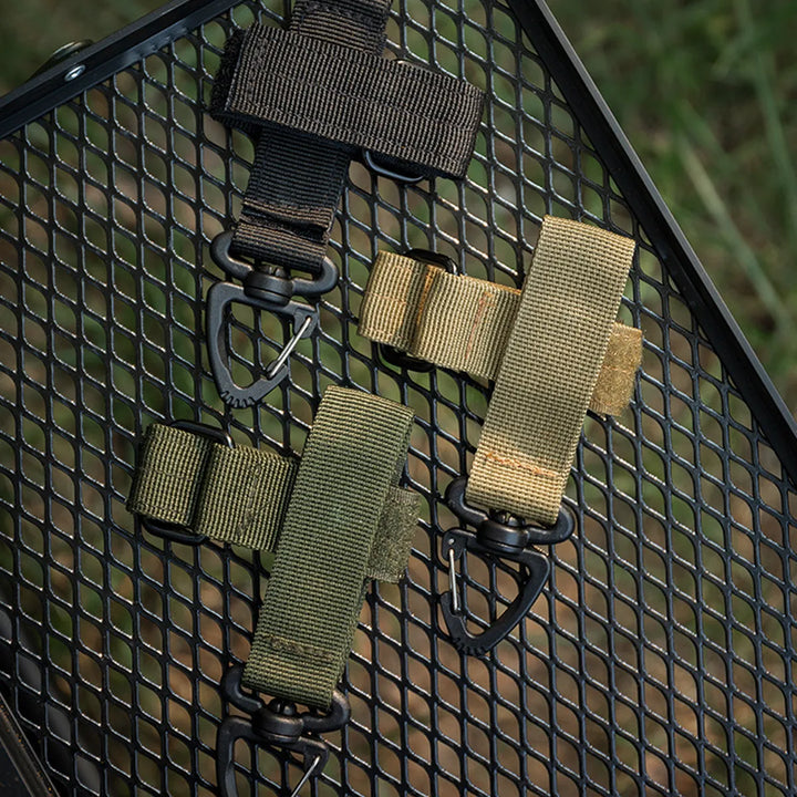 Hand holding a tactical glove holder clip, emphasizing its ergonomic design and ease of use for outdoor activities.