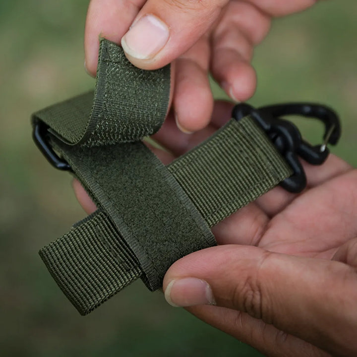 Tactical clip used to secure a water bottle, showcasing its versatility beyond just glove holding as emergency tool.