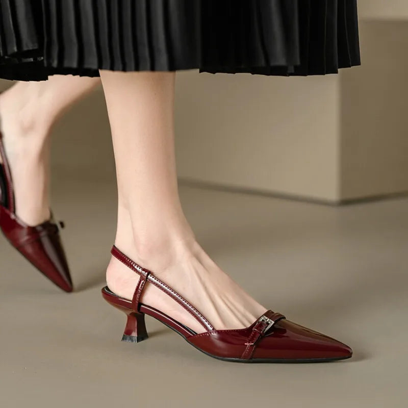 Elegant women's slingback kitten heels with a sophisticated pointed toe, classic black.