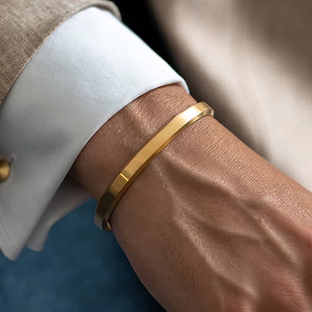 Modern minimalist stainless steel unisex cuff bracelet, available in gold, silver, rose gold, and black.