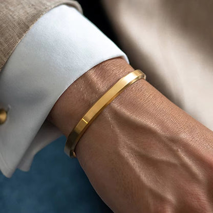Modern minimalist stainless steel unisex cuff bracelet, available in gold, silver, rose gold, and black.