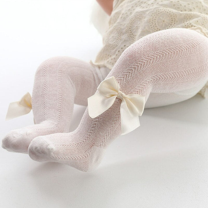 Comfortable beige toddler leggings with bow accent for baby girls. Soft fabric for spring and autumn apparel.