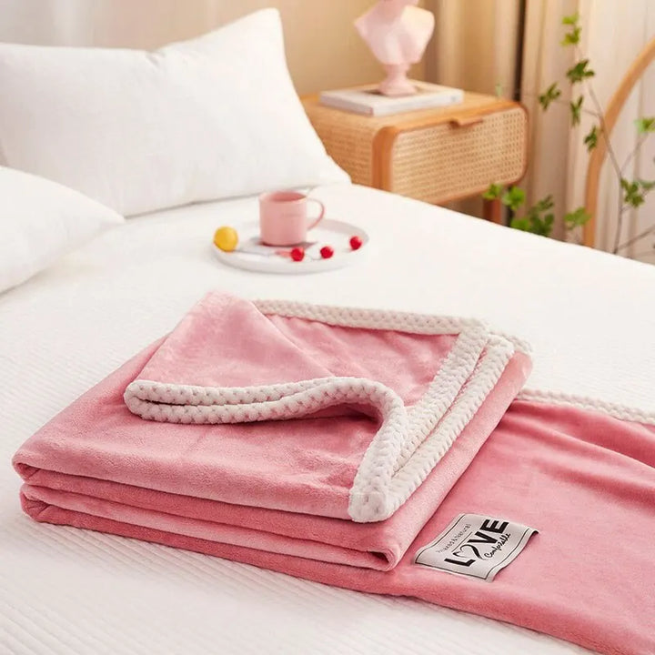 Cozy pink flannel fleece throw blanket, perfect for adding warmth and plush comfort to any living room or bedroom.