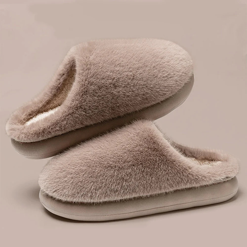 Warm burgundy plush women's slippers on a cozy rug, ideal house shoes for ultimate indoor relaxation.