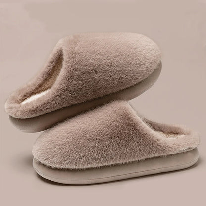 Warm burgundy plush women's slippers on a cozy rug, ideal house shoes for ultimate indoor relaxation.