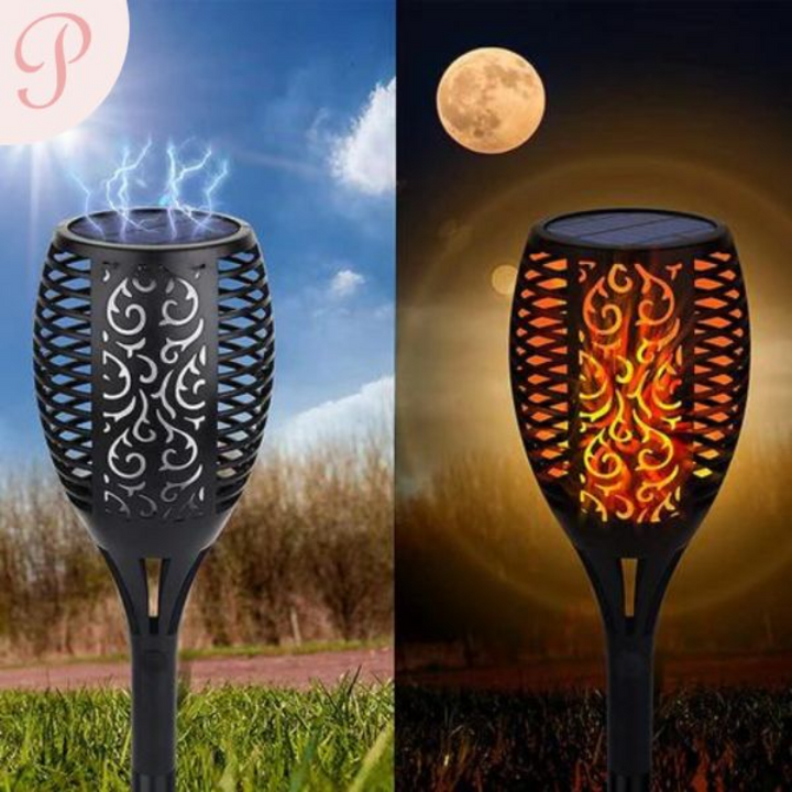 Set of SolarFlame LED garden torches illuminating a patio, adding warm ambient flame effect lighting & decor.