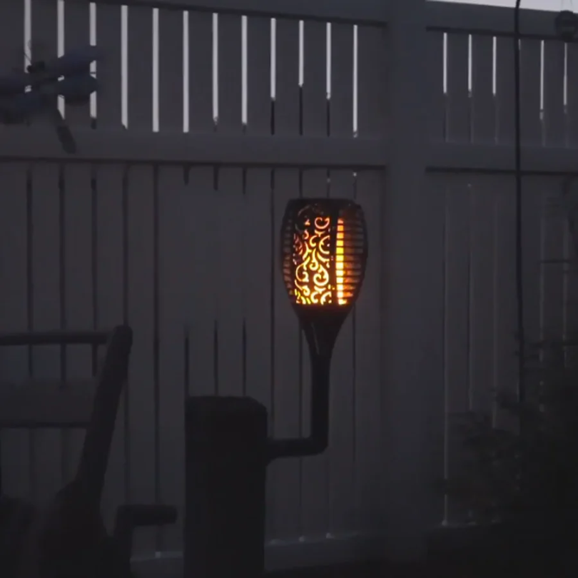 Close-up of a SolarFlame LED torch with flickering flame effect, ideal for solar landscape & backyard lighting.
