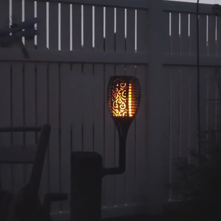 Close-up of a SolarFlame LED torch with flickering flame effect, ideal for solar landscape & backyard lighting.