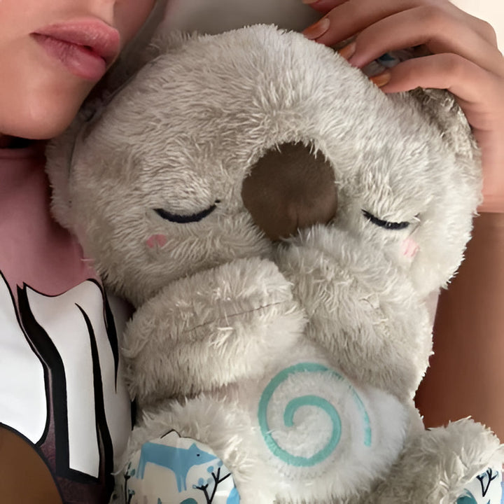 Soft Koala plush offering rhythmic breathing, gentle lights & music for stress & sleep aid.