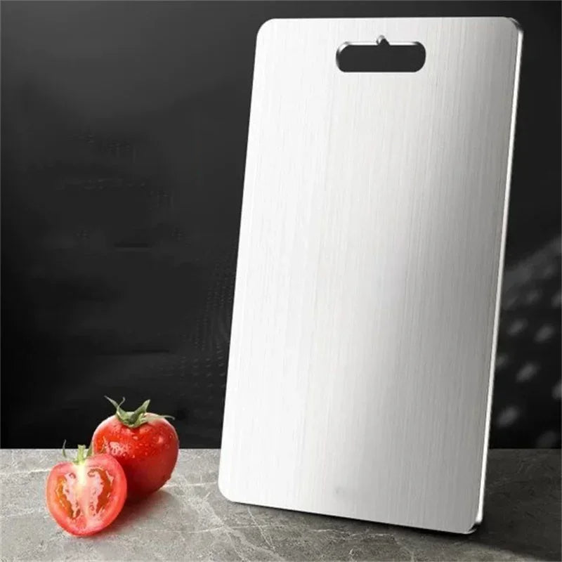 Home chef using a sleek stainless steel cutting board for efficient, hygienic vegetable chopping and food prep.
