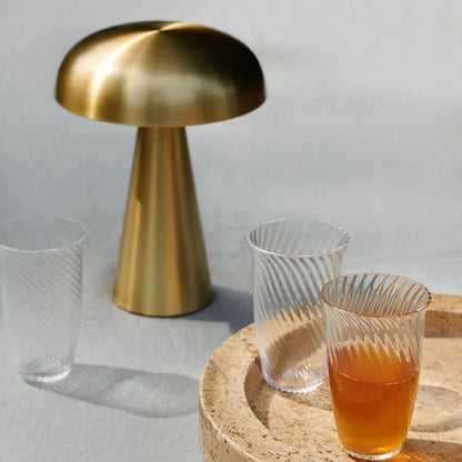 Modern portable LED desk lamp, gold finish mushroom design. Wireless & rechargeable accent light.