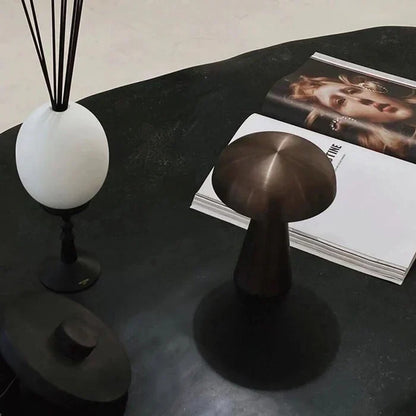 Elegant bronze portable LED lamp, mushroom design. Wireless & rechargeable for home and desk lighting.